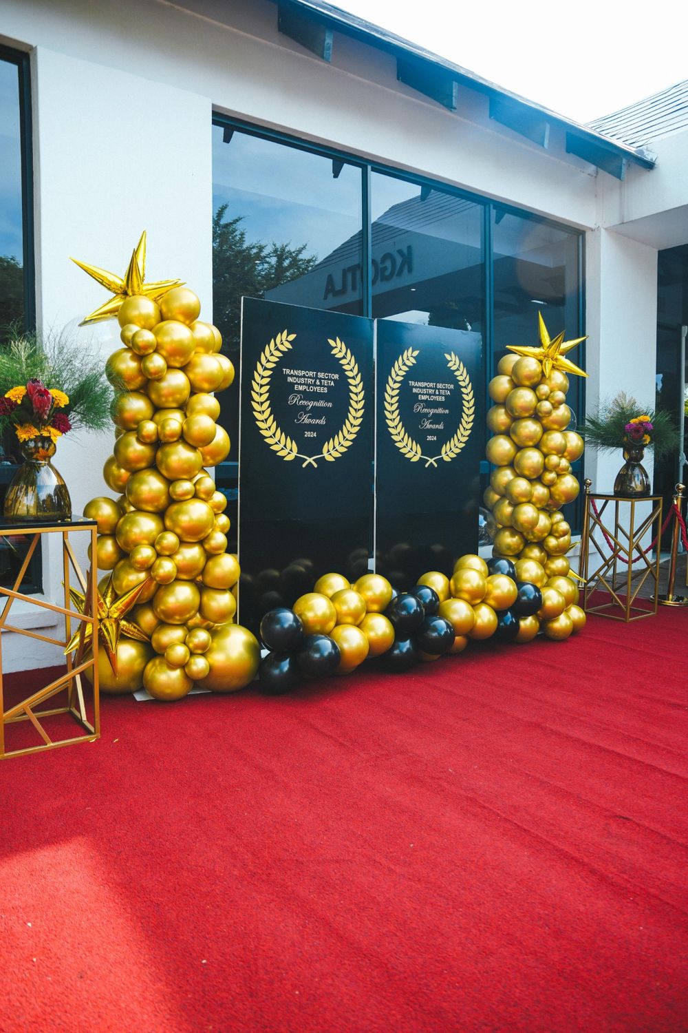 Red-carpet entrance with gold balloon towers and black Recognition Awards 2024 boards