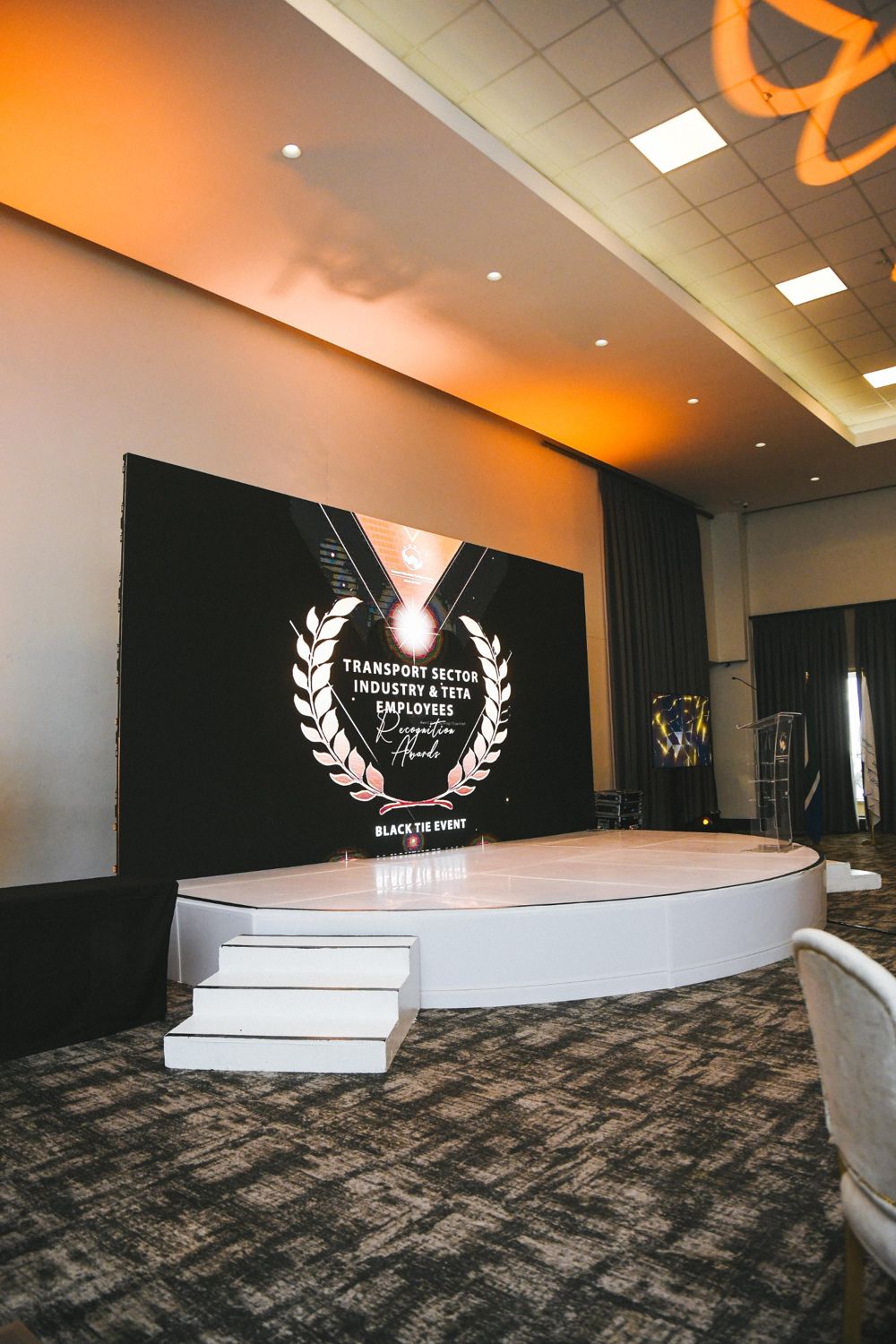 White round stage in front of an LED wall showing the Recognition Awards laurel logo