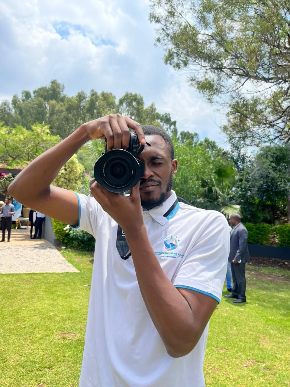 Wandii shooting with a camera outdoors at an event