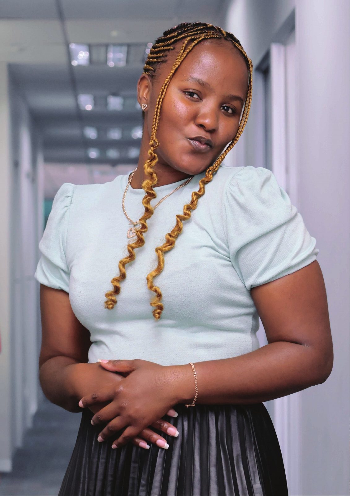 Woman with golden braids in an office corridor