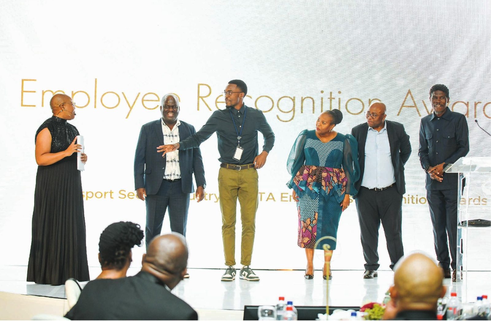 Award winners on stage in front of the Employee Recognition Awards backdrop